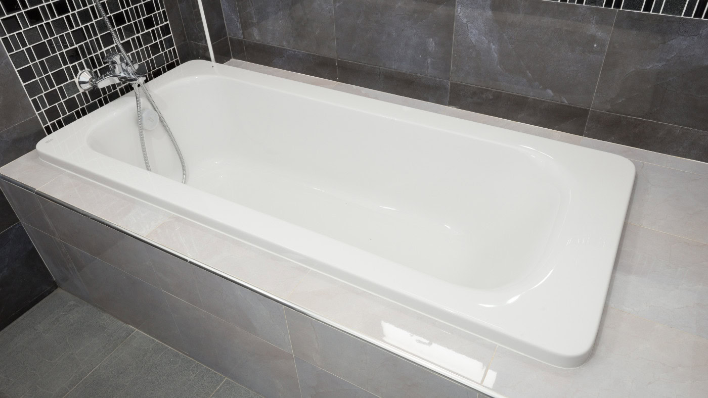 Weisse Badewanne in grauem Badezimmer